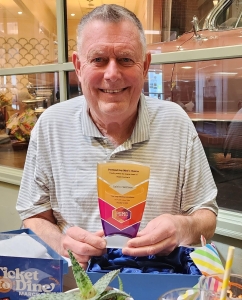 A man holds an award and smiles